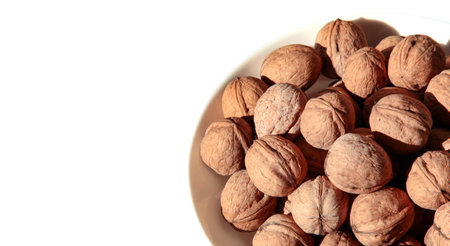 Bowl with walnuts isolated on white background.