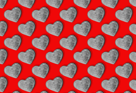 Seamless pattern with stone hearts on red.