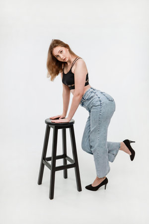 A woman in jeans and a black top on a white background.の写真素材