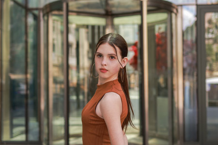 A girl with freckles near a skyscraper.の写真素材
