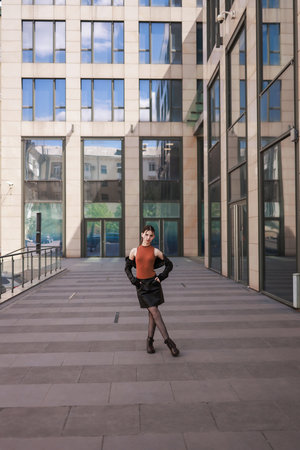 A girl with freckles in a leather skirt near a skyscraper.の写真素材