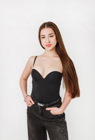 Portrait of a girl in jeans on a light background.の写真素材