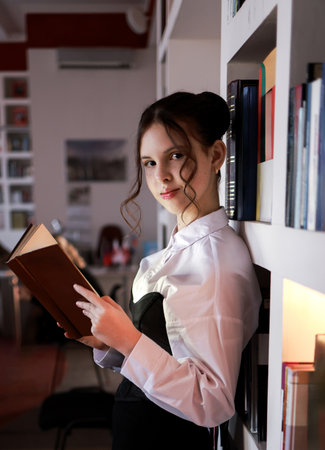 A girl in the library with a book.の写真素材