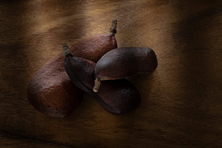 Delicious fruit of carob tree on a wooden background