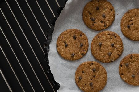 Oatmeal cookies and chocolate chips on black backgroundの写真素材