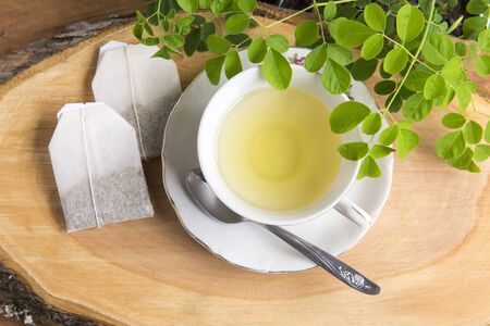 Moringa tea, leaves, seeds, powder on a wooden background - Moringa oleiferaの写真素材