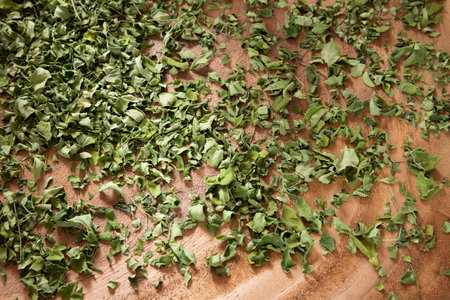 Dehydrated moringa leaves on a wooden background - Moringa oleifera