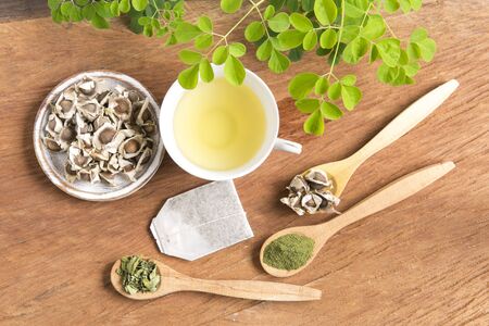 Moringa tea, leaves, seeds, powder on a wooden background - Moringa oleiferaの写真素材