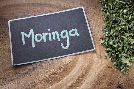 The word Moringa on a wooden background - Moringa oleiferaの写真素材