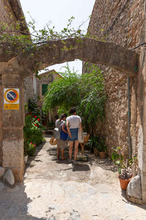 VALLDEMOSSA, PALMA DE MALLORCA, SPAIN. JULY 21, 2019. Two tourists buying lemons in one of the beautiful streets of the townのeditorial素材