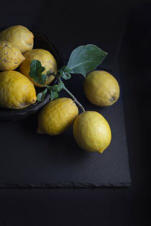 Basket with lemons, on black backgroundの写真素材