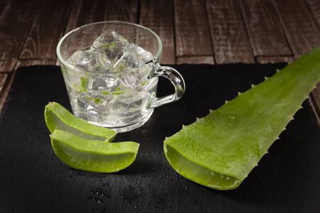 Black slate, glass with aloe vera juice, on a dark backgroundの写真素材