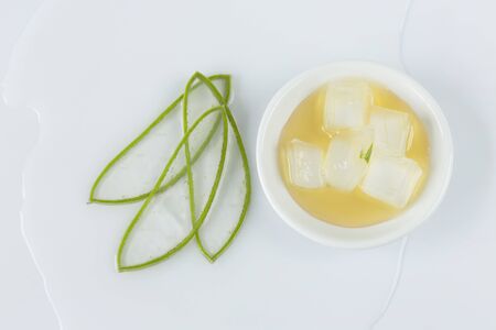 aloe vera leaves cut into thin slices, bowl with honey and pieces of aloe vera on white backgroundの写真素材