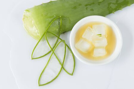 aloe vera leaves cut into thin slices, bowl with honey and pieces of aloe vera on white backgroundの写真素材