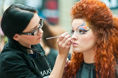 MOSCOW, RUSSIA - FEBRUARY 12: Stylist and his model prepare for the VIII Open Championship for creative makeup KOSMETIK international on February 12, 2011 in Moscow, Russia.のeditorial素材
