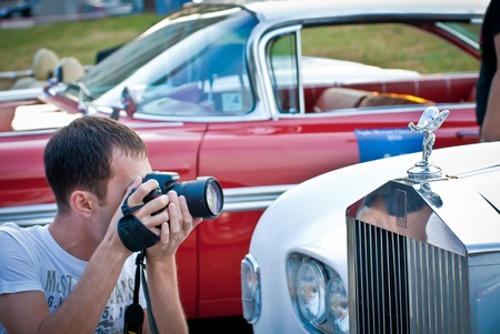 MOSCOW - JULY 31: Photographer and retro car on exhibition parking at an annual event the VI race of vintage cars 'Night Moscow Classic Rally'. July 31, 2010 in Moscow, Russiaのeditorial素材
