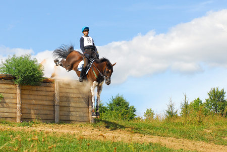 MOSCOW - AUGUST 21: Vakin Maksim on Harlej-Devidson on a Russian Cross-Country Championship, August 21, 2010 in Moscow, Russia/Rider horseback on galloping brown chestnut horseのeditorial素材