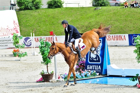 MOSCOW, RUSSIA-JUNE 26: Rider Tuganov Vladimir (RUS) wiht A Belgian half-breed horse Blyubaster competes at the International event CSI4*RR/ Russian Championship Show Jumping on June 26, 2011 in Moscow, Russiaのeditorial素材