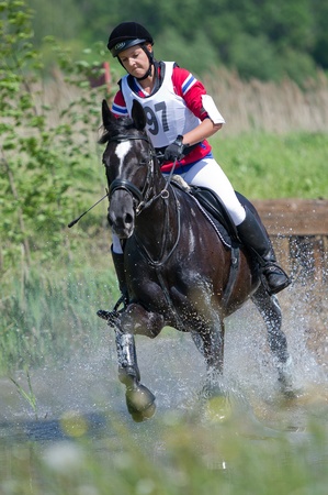 MOSCOW - JUNE 02  Unidentified rider on horse  Horse and girl negotiating cross country fence Water jump at the International Eventing Competition CCI3 2  1 Russian Cup Eventing June 02, 2012 in Moscow, Russiaのeditorial素材