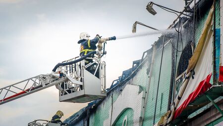 Firefighters in action fighting fire. firefighter smoke shed roofの写真素材