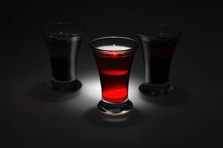 Three two color double alcoholic short drink on black white backgroundの写真素材