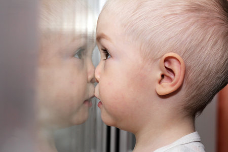 the baby near the window, pretty boyの写真素材