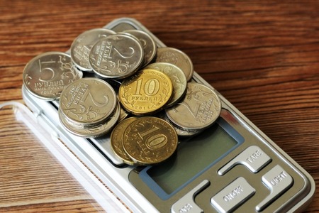 Coins on scale, electronic scales, measuring instrument moneyの写真素材