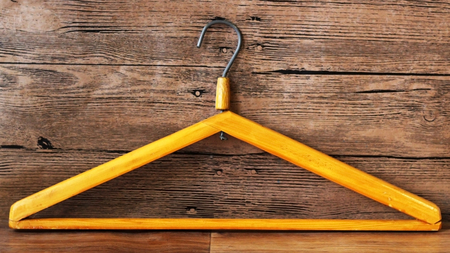Wooden clothes hangers on wooden background. What nothing to wear conceptの写真素材