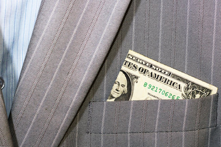 Money American Dollar Pile Stuck Out Of Military Khaki Coat or Bag Pocket With American Flag Patch,...