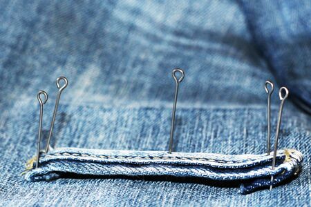 Texture of vintage blue jeans background and metal pinsの写真素材