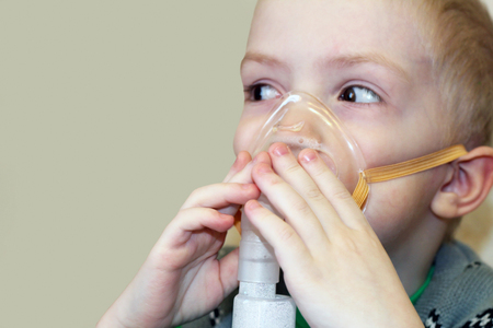 Child holds a mask vapor inhalerの写真素材