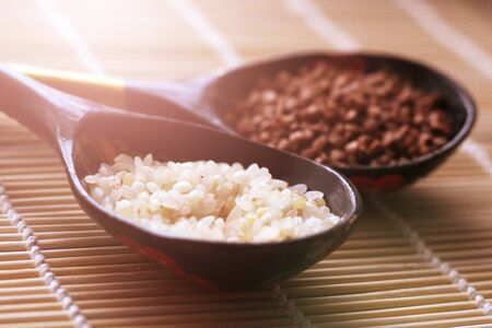 Dry white colored rice in wooden spoon, foodの写真素材