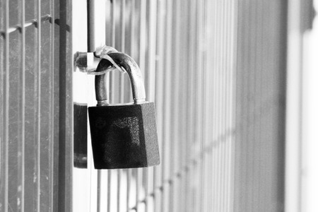 A rusty chain on a weathered metal door with a padlock, objectの写真素材