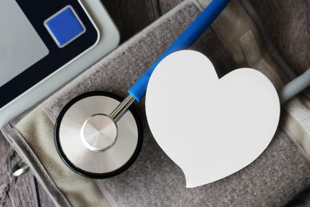 Sphygmomanometer and stethoscope kit used to measure blood pressure on wooden tableの写真素材