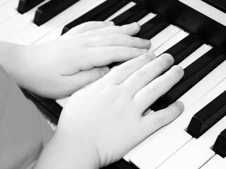 Little boy playing the synthesizer, learning the gameの写真素材