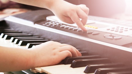 Little boy playing the synthesizer, learning the gameの写真素材