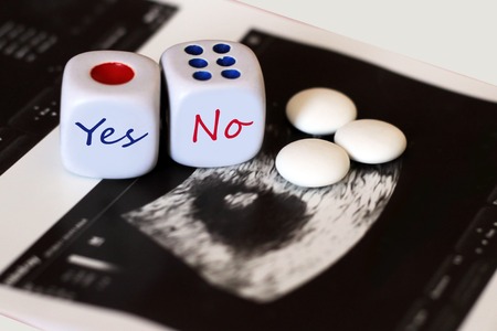 Ultrasound of baby in mother's womb. Playing cubes with inscriptions and tablets. Health.の写真素材