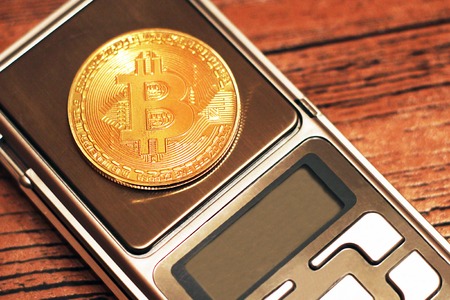 Bitcoin on the electronic scales. New cryptocurrency.の写真素材