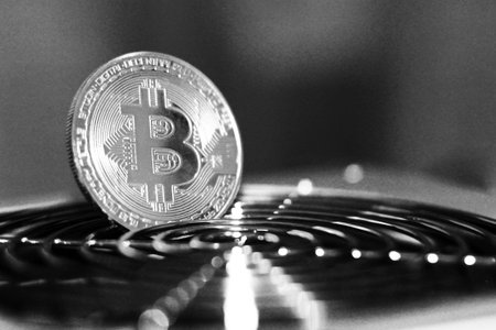 Golden Bitcoin virtual currency on a circuit board background, object