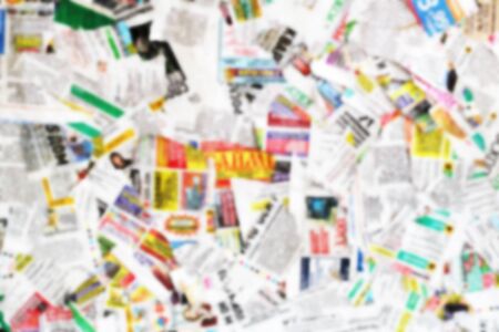 Lots of old newspapers on horizontal surface. Background texture, top view, blurredの写真素材