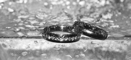 Wedding rings and water. grey background, goldenの写真素材