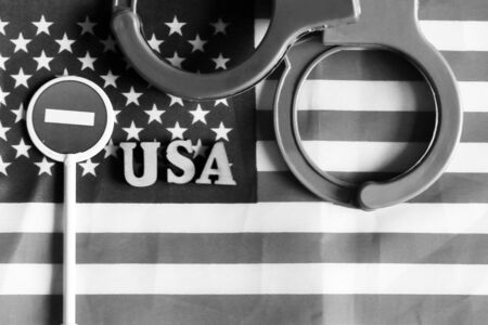 Road stop sign and handcuffs on a background of America flag, objectの写真素材