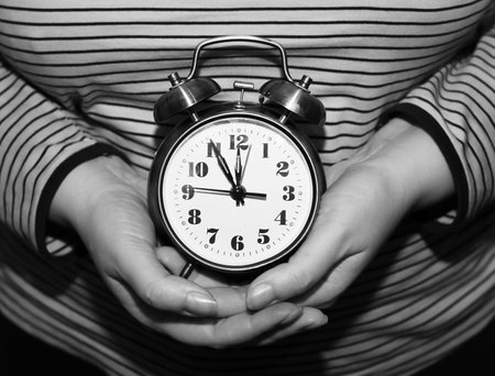 Female hands holding golden alarm clock, objectの写真素材