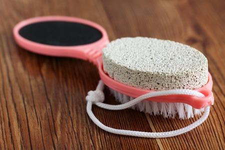 Pink pumice for female feet on wooden background, plasticの写真素材