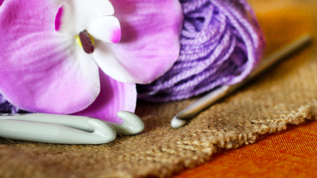 Hooks for knitting, purple yarn, and a beautiful Orchid, objectの写真素材