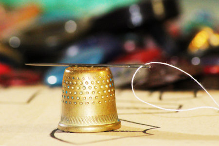 Old Brass Thimble with a Threaded Needle, golden