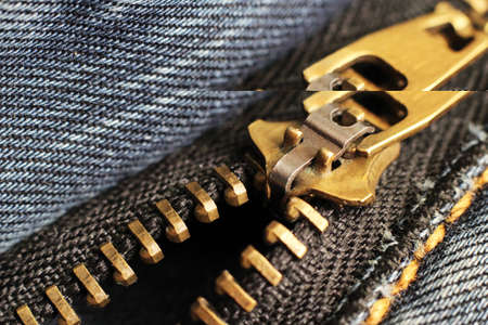 black zipper and lock on jeans background, so close