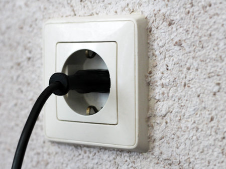 Electric light switch and socket on the empty wall, electrical power socket and plug switched,...