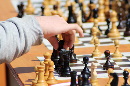 Child playing chess, children's hand, game education