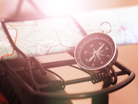 Compass and map on the bike trunk, sunlight